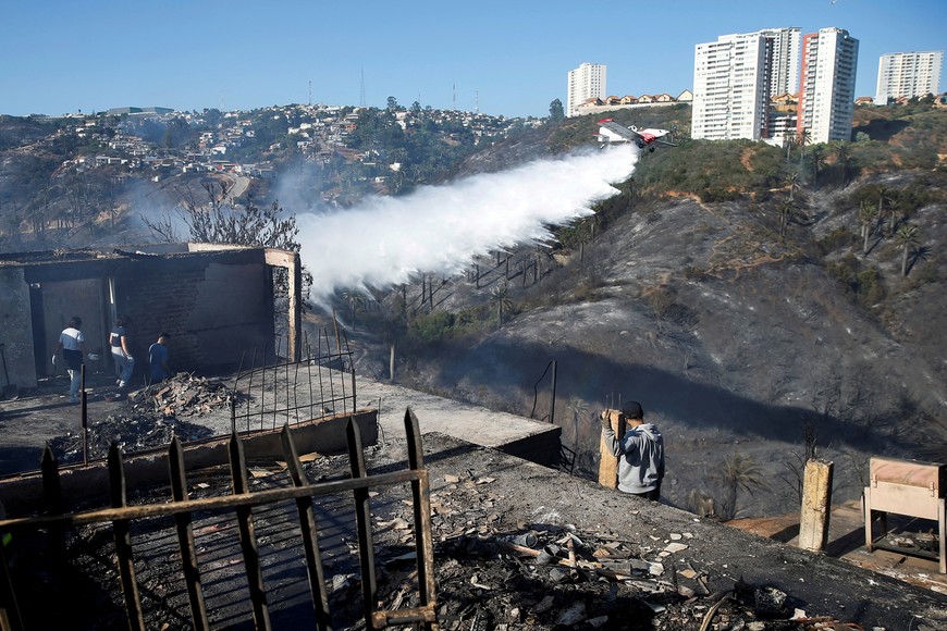 An aircraft makes a water drop after a wildfire in Vina del Mar, Chile December 23, 2022. REUTERS/Rodrigo Garrido