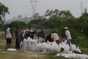 ELLITORAL_142401 |  Mauricio Garín Terraplén. En la defensa de ese barrio costero, vecinos y voluntarios ubicaban las bolsas con arena para fortalecer la defensa y evitar el ingreso del agua. El trabajo es a destajo.