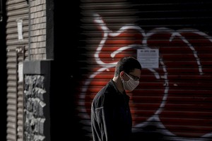 ELLITORAL_305343 |  Xinhua/Rahel Patrasso Un hombre porta un barbijo mientras camina frente a tiendas cerradas en Sao Paulo.