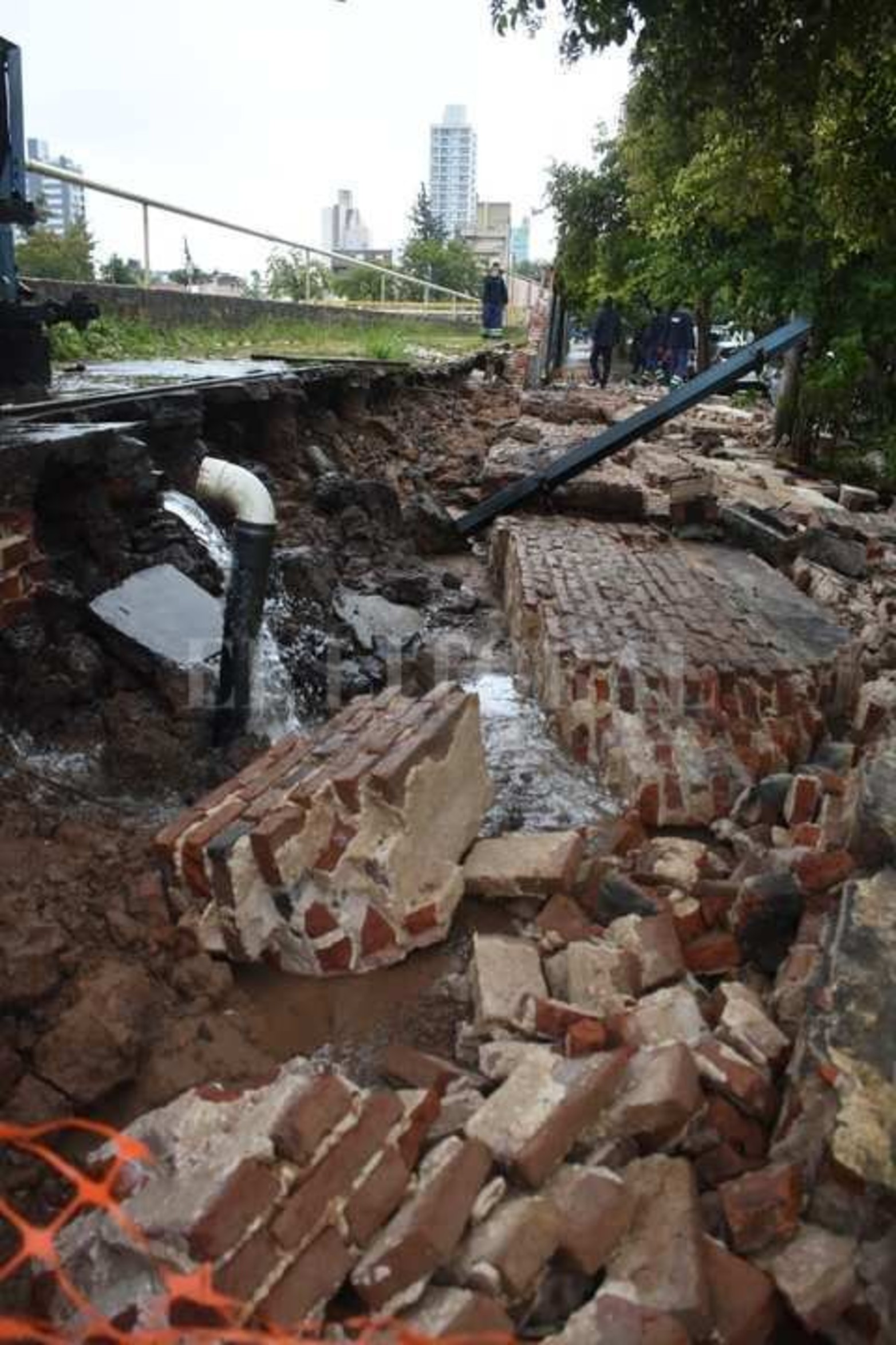 El muro ubicado sobre calle Lavalle se desplomó. Los escombros quedaron desparramados sobre la vereda y el agua de una de las piletas está drenando hacia la calle.
