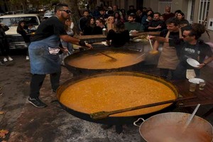 Los ollones llenos de locro eran un llamador a los sentidos. Detrás, la fila de gente esperando.