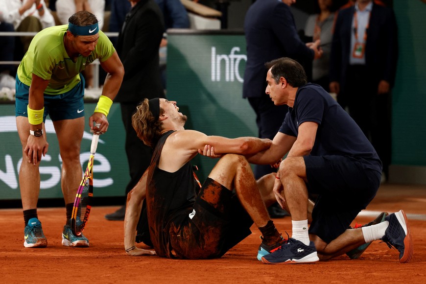 Tennis - French Open - Roland Garros, Paris, France - June 3, 2022
Germany's Alexander Zverev receives medical attention after sustaining an injury as Spain's Rafael Nadal looks on REUTERS/Yves Herman