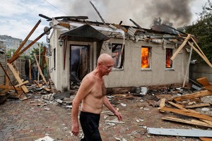 A local resident walks, as his neighbour's house burns after shelling, as Russia's attack on Ukraine continues, in Lysychansk, Luhansk region Ukraine June 2, 2022. REUTERS/Serhii Nuzhnenko