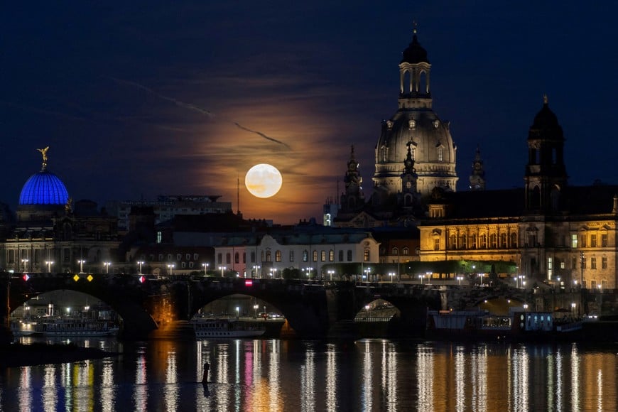 A full moon known as the "Strawberry Moon" rises behind the old town district, in Dresden, Germany, June 14, 2022. Picture taken June 14, 2022. REUTERS/Matthias Rietschel     TPX IMAGES OF THE DAY