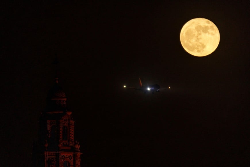 A southwest airline commercial aircraft approaches to land as a strawberry super moon rises behind the California Tower, at Balboa Park in San Diego, California , U.S., June 14, 2022.    REUTERS/Mike Blake