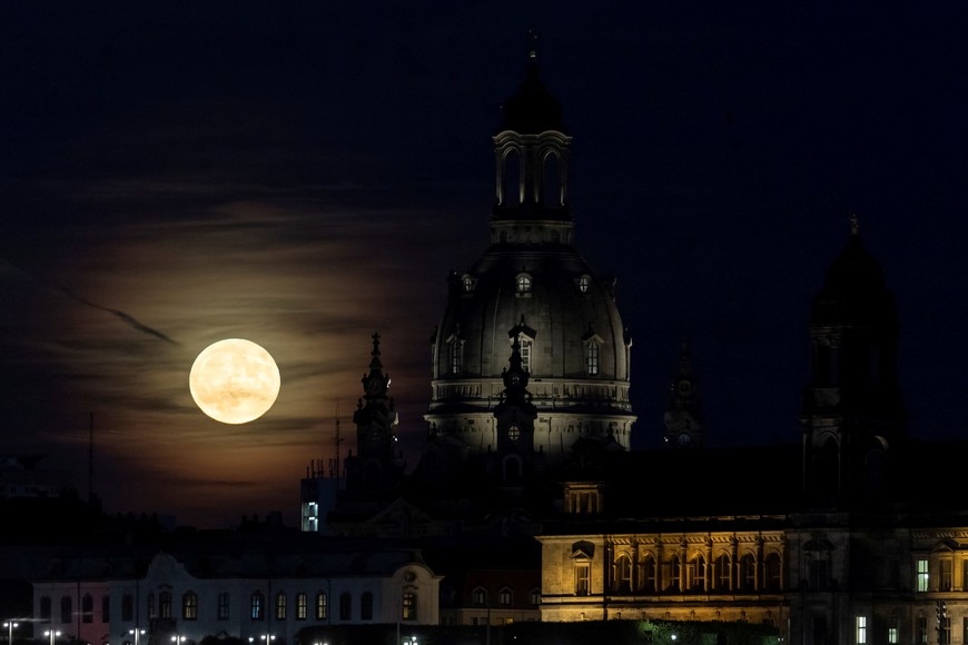 A full moon known as the "Strawberry Moon" rises behind the old town district in Dresden, Germany, June 14, 2022. Picture taken June 14. REUTERS/Matthias Rietschel