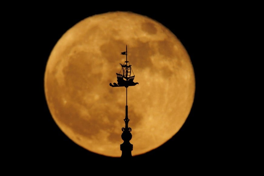 A full strawberry super moon rises behind the top of the California Tower, constructed for the 1915 Panama-California Exposition, at Balboa Park in San Diego, California , U.S., June 14, 2022.    REUTERS/Mike Blake