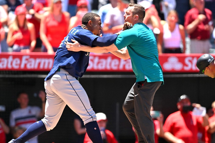 Jun 26, 2022; Anaheim, California, USA;  Seattle Mariners strength coach James Clifford holds back center fielder Julio Rodriguez (44) during a benches clearing brawl with the Los Angeles Angels in the second inning at Angel Stadium. Mandatory Credit: Jayne Kamin-Oncea-USA TODAY Sports