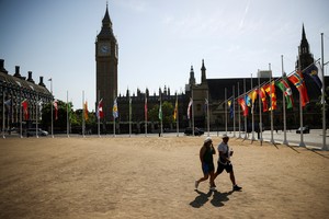 People cross the grounds of Parliament Square, during a heatwave in London, Britain, July 19, 2022. REUTERS/Henry Nicholls