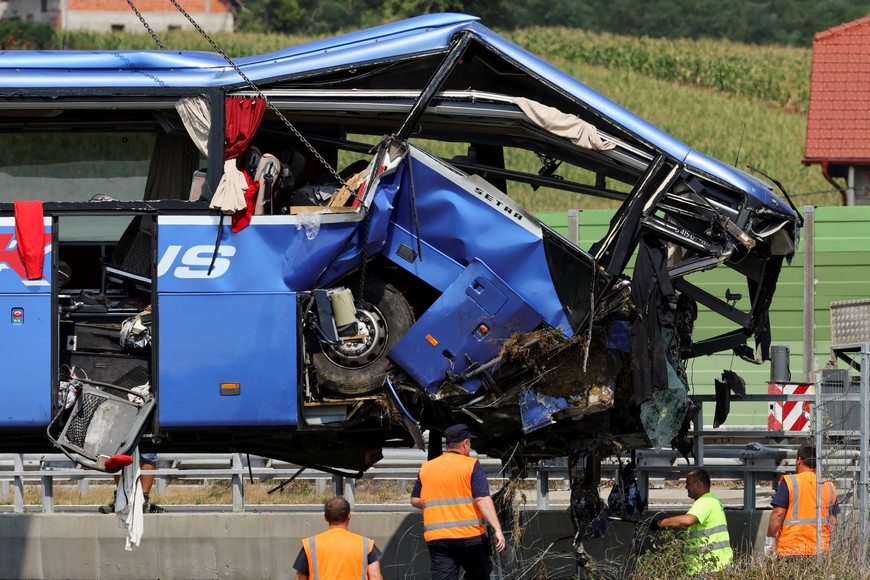 Rescuers work as a crane removes the bus with Polish licence plates that slipped off a road, from the scene near Varazdin, northwestern Croatia, August 6, 2022. REUTERS/Antonio Bronic