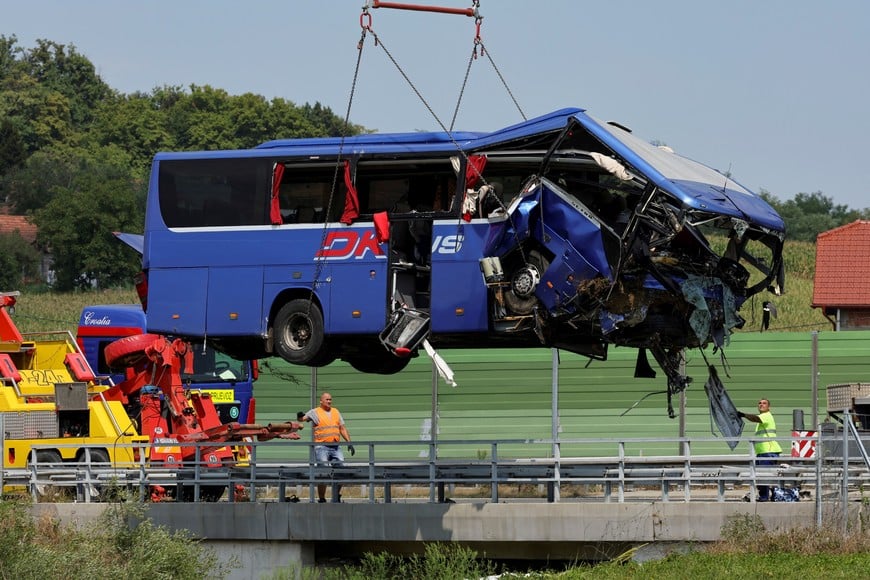 A crane removes the bus with Polish licence plates that slipped off a road, from the scene near Varazdin, northwestern Croatia, August 6, 2022. REUTERS/Antonio Bronic