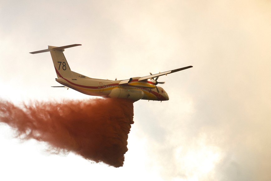 A firefighting plane drops flame retardant to extinguish a fire in Belin-Beliet, as wildfires continue to spread in the Gironde region of southwestern France, August 10, 2022. REUTERS/Stephane Mahe