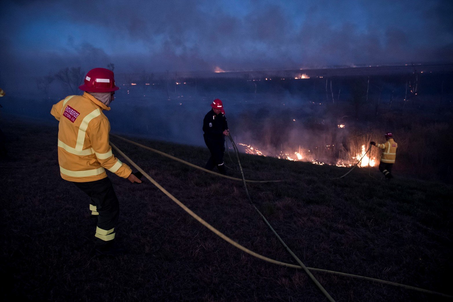 Trabajo hormiga. Las dotaciones de bomberos solo pueden llegar si tienen un acceso seguro, como lo es la conexión vial que une Rosario con Victoria. Foto Marcelo Manera.