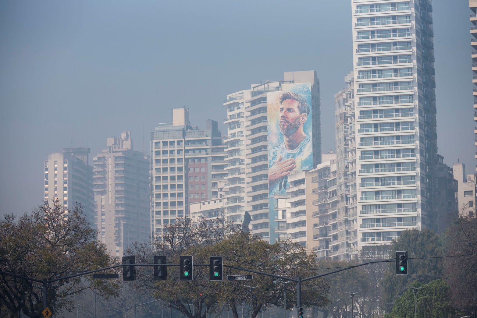 Messi con humo. El gigante mural de Leonel Messi apenas se deja ver.