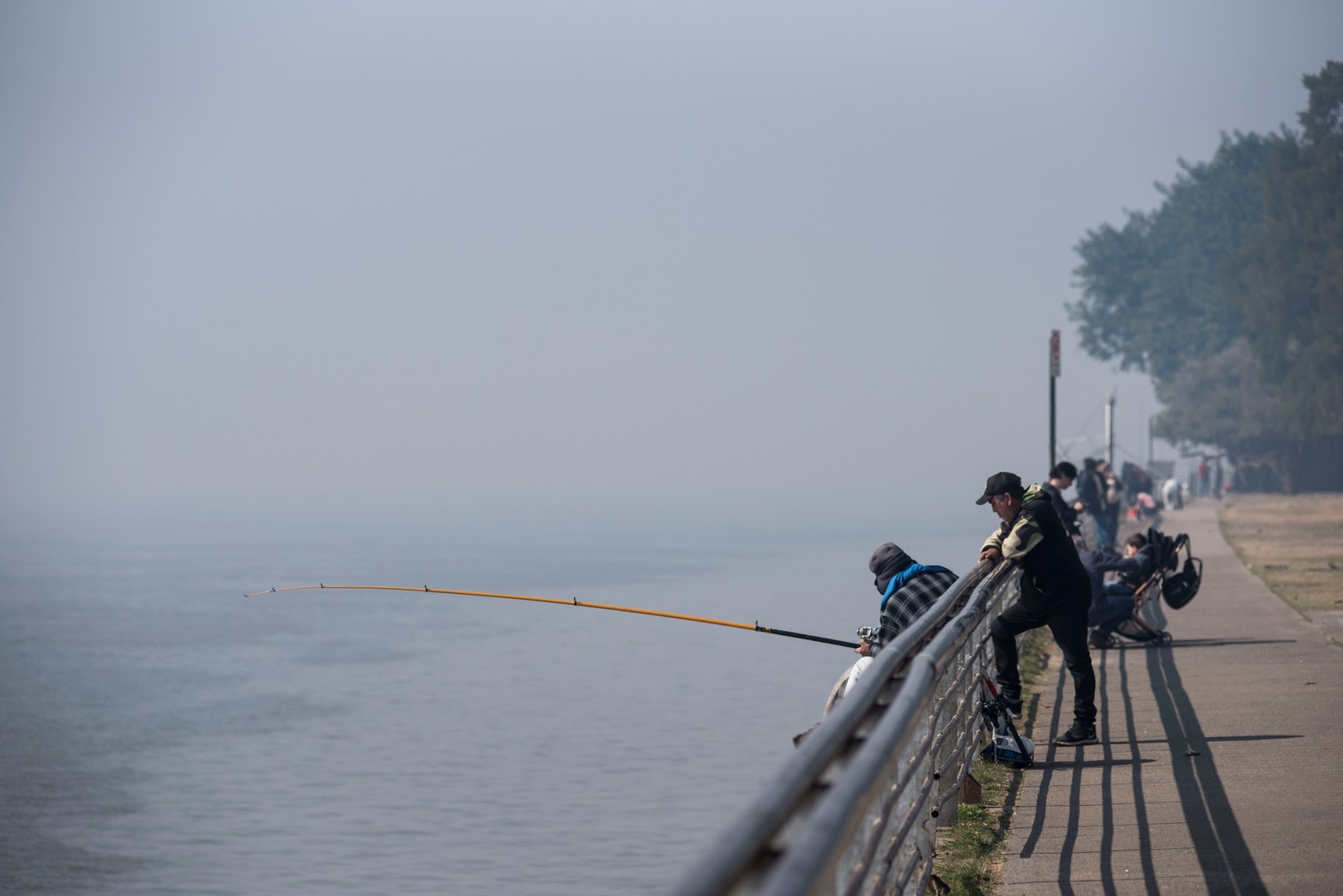 A río revuelto...Ganancia para el pescador. El humo no impidió a estos pescadores tirar la línea con la plomada y el anzuelo.