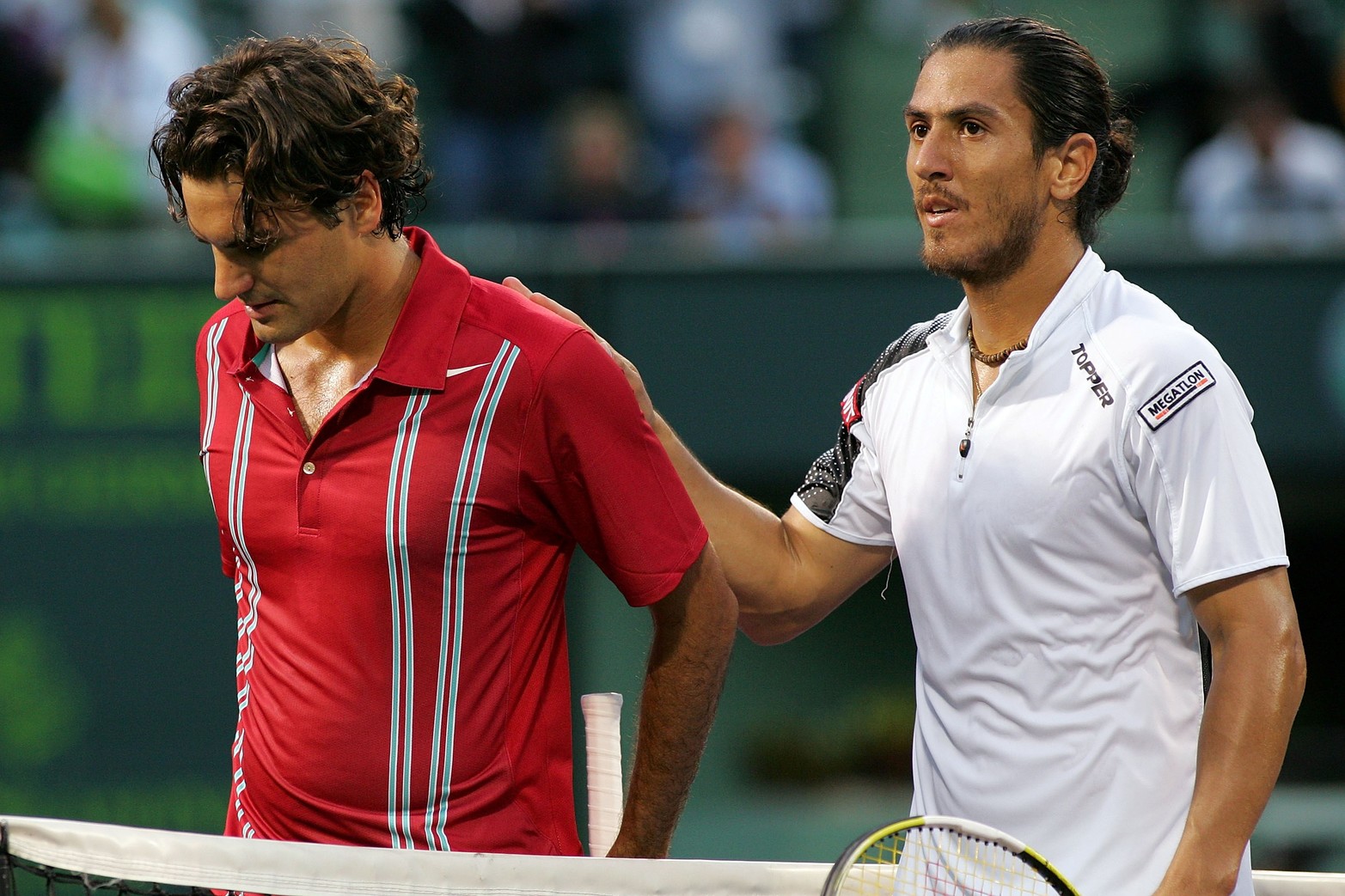 Guillermo Cañas le da una palmadita en la espalda a Roger Federer después de derrotarlo al Suizo en el Sony Ericsson Open 2007 el 27 de marzo en Miami, Florida. Matthew Stockman/Getty Images