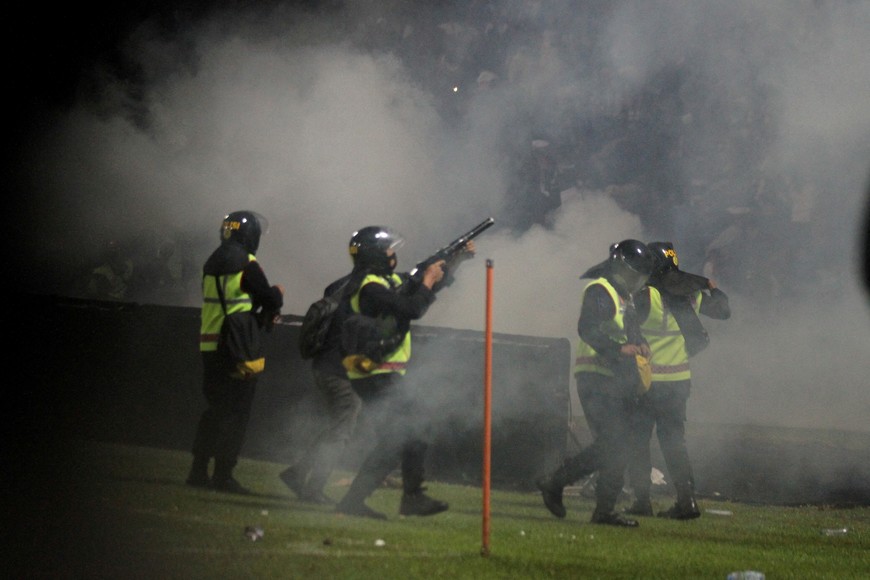 A riot police officer fires tear gas during a riot after the league BRI Liga 1 football match between Arema vs Persebaya at Kanjuruhan Stadium in Malang, East Java province, Indonesia, October 2, 2022, in this photo taken by Antara Foto. Antara Foto/Ari Bowo Sucipto/via REUTERS  ATTENTION EDITORS - THIS IMAGE HAS BEEN SUPPLIED BY A THIRD PARTY. MANDATORY CREDIT. INDONESIA OUT. NO COMMERCIAL OR EDITORIAL SALES IN INDONESIA.     TPX IMAGES OF THE DAY