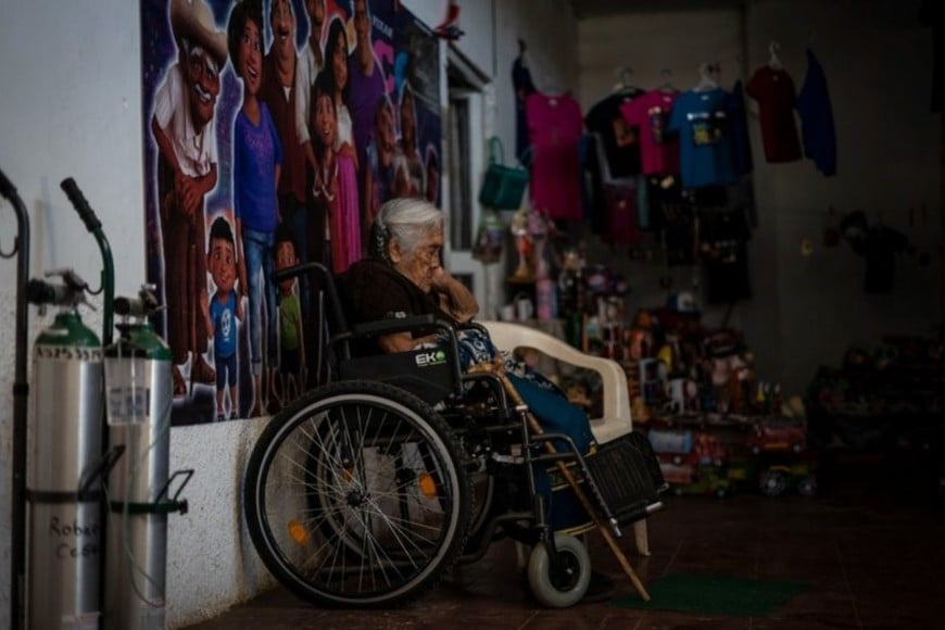 Doña María Salud aguardando para posar junto a los turistas. Crédito: El País.