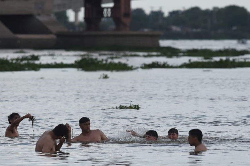 El calor de este sábado despertó tempranamente la presencia de personas en la Laguna Setúbal, a pesar de la importante presencia de camalotes. Crédito: Mauricio Garín.