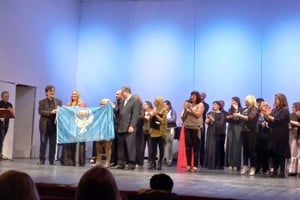 Agrupación Coral de Santo Tomé con la Bandera de la Paz, en el Teatro 1° de Mayo