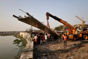 People remove debris after a suspension bridge collapsed in Morbi town in the western state of Gujarat, India, October 31, 2022. REUTERS/Stringer NO RESALES. NO ARCHIVES.