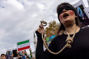 A member of the Iranian community living in Turkey holds a rope as letters on her neck reads, "#no to death penalty" during a protest in support of Iranian women, after the death of Mahsa Amini, in Istanbul, Turkey November 19, 2022. REUTERS/Umit Bektas