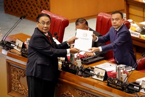 Bambang Wuryanto, head of the parliamentary commission overseeing the revision, passes the report of the new criminal code to Sufmi Dasco Ahmad, Deputy speaker of the House of Representatives, during a parliamentary plenary meeting in Jakarta, Indonesia, December 6, 2022. REUTERS/Willy Kurniawan