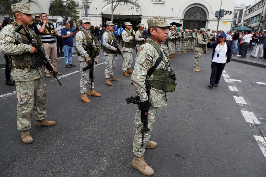 Members of the Military stand guard, as supporters of Peru's former President Pedro Castillo gather outside the police prison where Castillo is being held, prosecutors said they were seeking 18 months of pretrial detention for Castillo, in Plaza San Martin, Lima, Peru December 15, 2022. REUTERS/Sebastian Castaneda