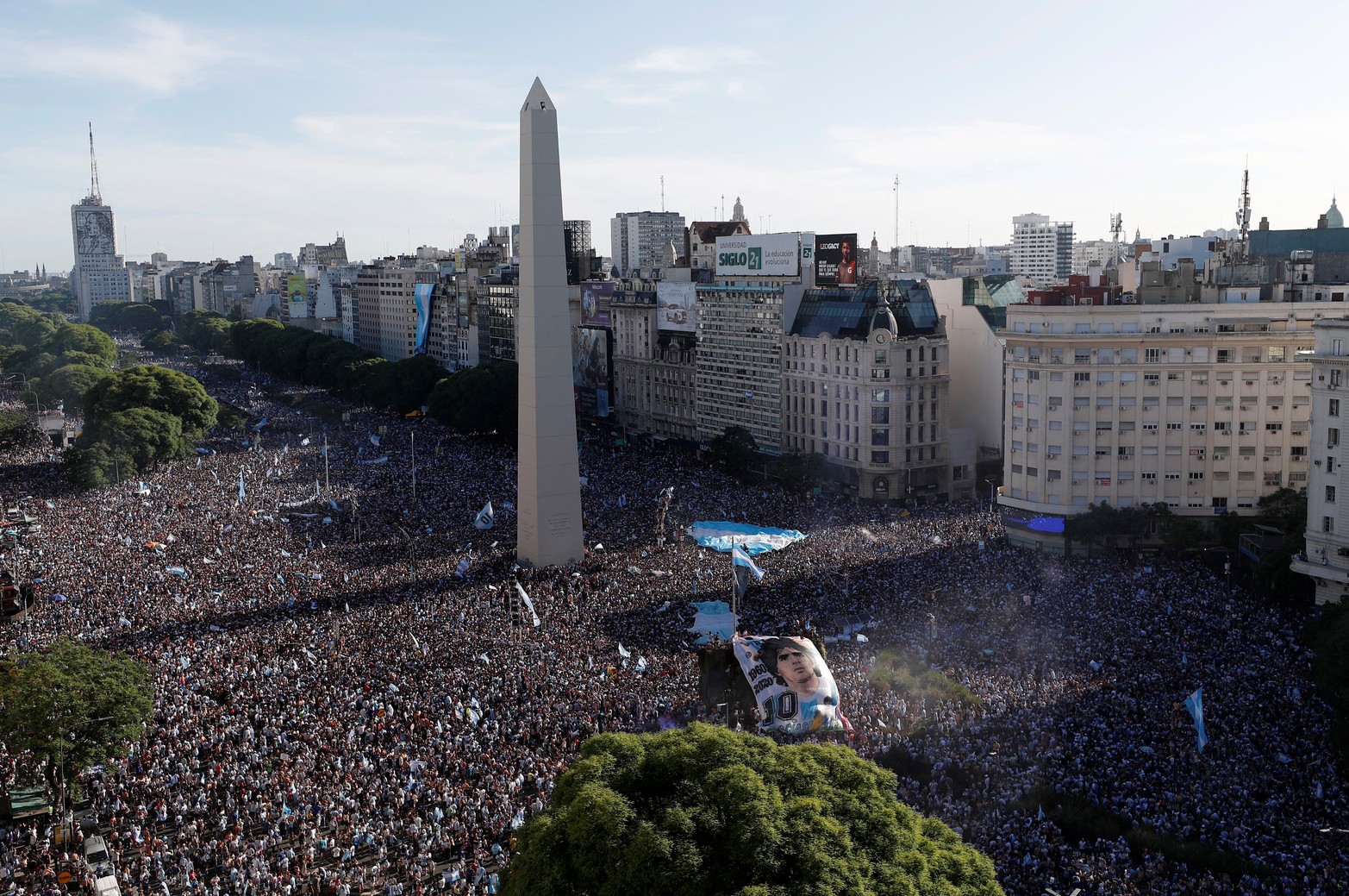 Soccer Football - FIFA World Cup Final Qatar 2022 - Fans in Buenos Aires - Buenos Aires, Argentina - December 18, 2022 
General view as Argentina fans with a Diego Maradona banner celebrate after winning the World Cup by the Obelisco REUTERS/Agustin Marcarian