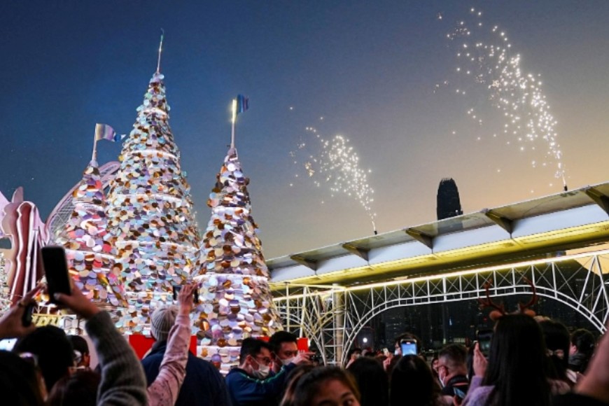 La gente toma fotos de las decoraciones navideñas durante una ceremonia de iluminación navideña en un centro comercial en Hong Kong, China. Crédito: Lam Yik / Reuters