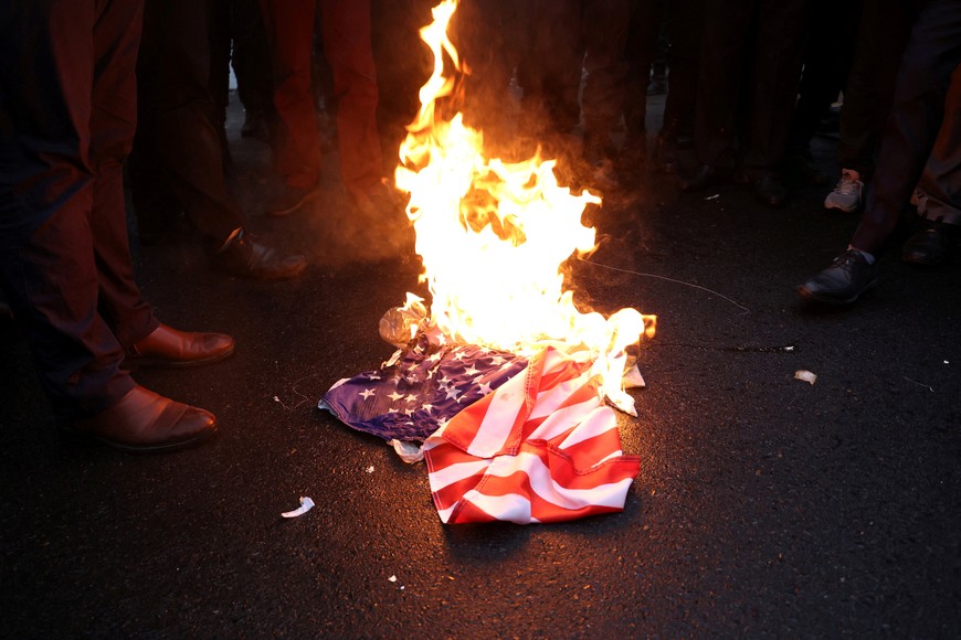 Demonstrators burn U.S flag during a protest to condemn the French magazine Charlie Hebdo for republishing cartoons insulting Iran's Supreme Leader Ayatollah Ali Khamenei, in front of the French Embassy in Tehran, Iran, January 11, 2023. Majid Asgaripour/WANA (West Asia News Agency) via REUTERS ATTENTION EDITORS - THIS PICTURE WAS PROVIDED BY A THIRD PARTY