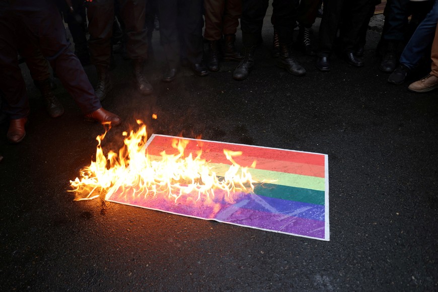 Demonstrators burn a rainbow flag during a protest to condemn the French magazine Charlie Hebdo for republishing cartoons insulting Iran's Supreme Leader Ayatollah Ali Khamenei, in front of the French Embassy in Tehran, Iran, January 11, 2023. Majid Asgaripour/WANA (West Asia News Agency) via REUTERS ATTENTION EDITORS - THIS PICTURE WAS PROVIDED BY A THIRD PARTY