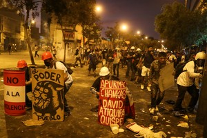 Demonstrators cover behind makeshift shields during an anti-government demonstration following the ouster of Peru's former President Pedro Castillo, in Lima, Peru January 26, 2023. REUTERS/Sebastian Castaneda