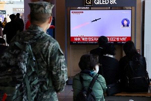 Unas personas observan un televisor que emite una noticia sobre el lanzamiento de tres misiles balísticos al mar por parte de Corea del Norte, en Seúl, Corea del Sur. 2 de noviembre de 2022. Yonhap vía REUTERS