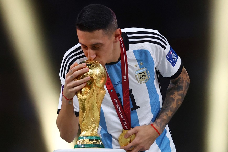 Soccer Football - FIFA World Cup Qatar 2022 - Final - Argentina v France - Lusail Stadium, Lusail, Qatar - December 18, 2022
Argentina's Angel Di Maria kisses the World Cup trophy after receiving his medal as he celebrates after winning the World Cup REUTERS/Kai Pfaffenbach