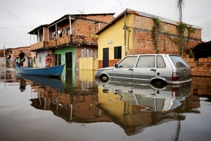 FILE PHOTO: People in a canoe cross a car on a flooded street during floods caused by heavy rain in Maraba, Para state, Brazil January 9, 2022. REUTERS/Ueslei Marcelino/File Photo