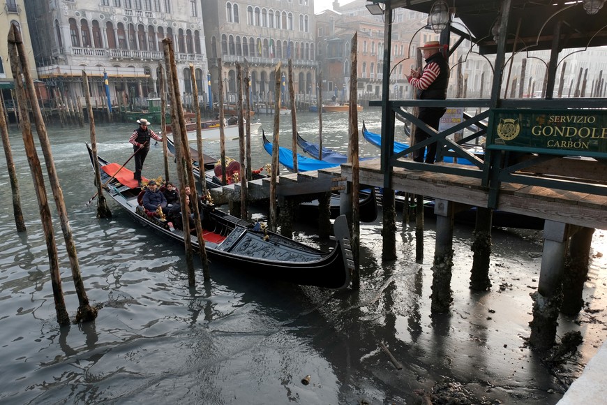 Gondolas are pictured in the Grand Canal during a severe low tide in the lagoon city of Venice, Italy, February 17, 2023. REUTERS/Manuel Silvestri REFILE - CORRECTING YEAR