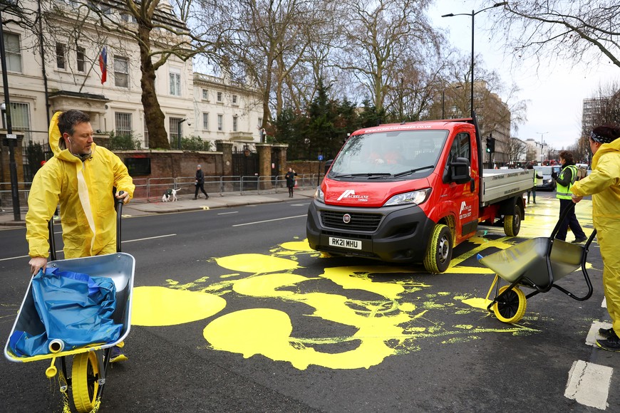 Protest group 'Led by Donkeys' pour yellow paint for the Ukrainian flag on a road, ahead of the first anniversary of Russia's invasion of Ukraine, outside the Russian Embassy in London, Britain February 23, 2023. REUTERS/Hannah McKay