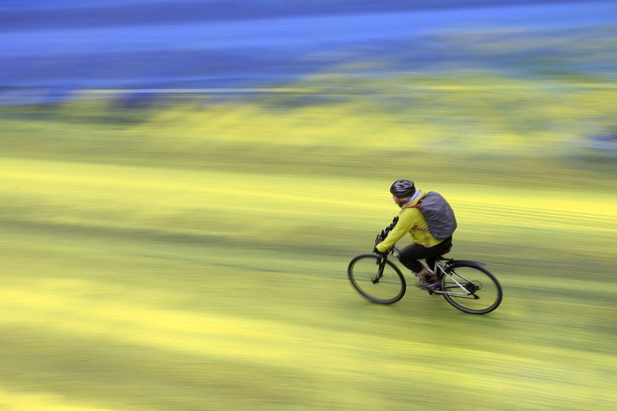 A cyclist rides on a painted road, after Protest group 'Led by Donkeys' spread paint in the colours of the Ukrainian flag on the road, ahead of the first anniversary of Russia's invasion of Ukraine, outside the Russian Embassy in London, Britain February 23, 2023. REUTERS/Hannah McKay     TPX IMAGES OF THE DAY