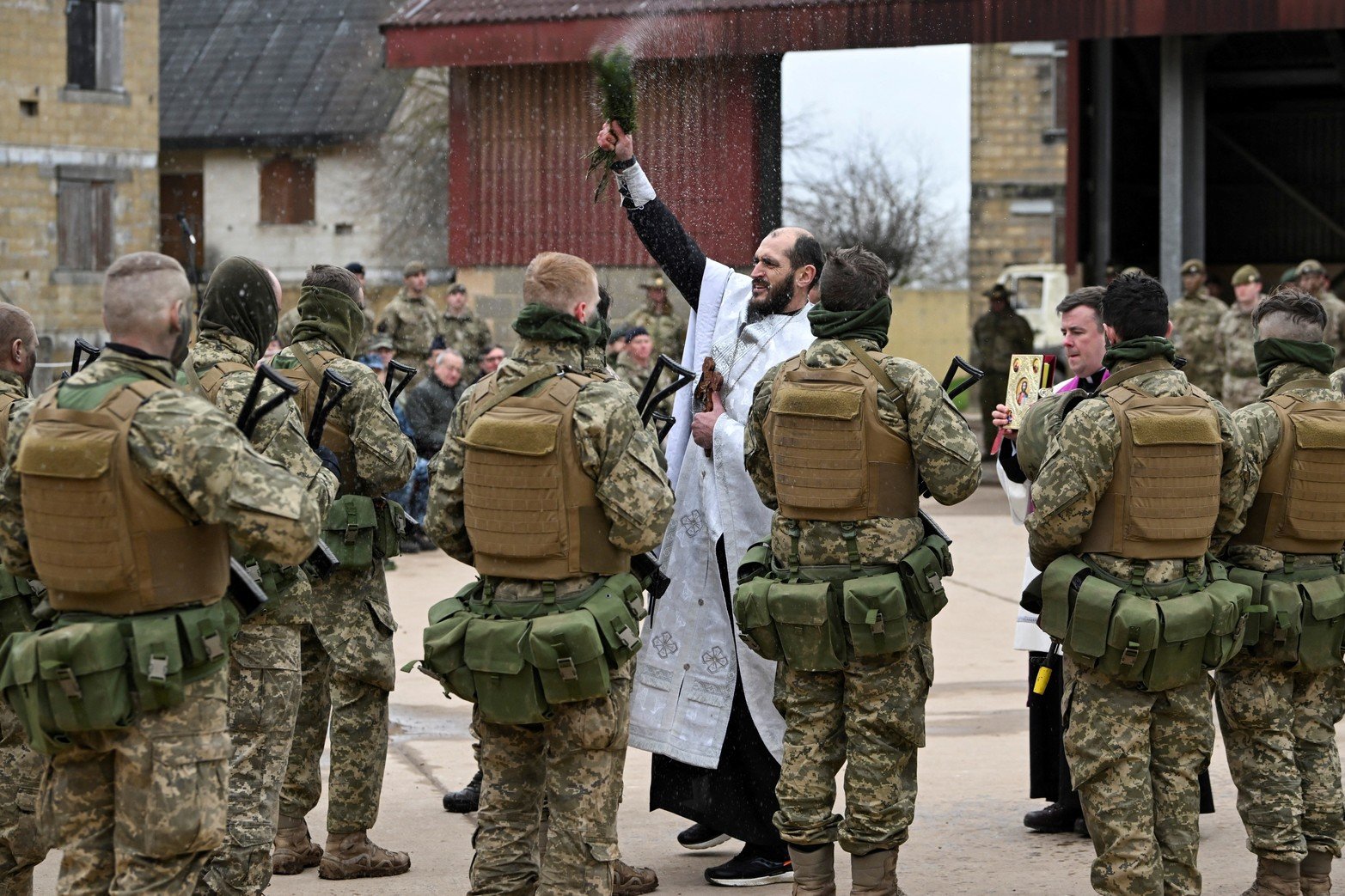 
Un sacerdote ortodoxo ucraniano bendice a los miembros de las Fuerzas Armadas de Ucrania durante una ceremonia para conmemorar un año desde que Rusia invadió Ucrania, en una base de entrenamiento cerca de Salisbury, Gran Bretaña, el 23 de febrero de 2023