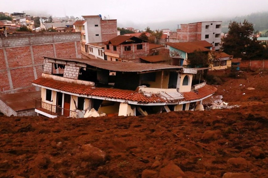 Una casa está parcialmente cubierta de lodo después de un deslizamiento de tierra provocado por fuertes lluvias. Créditos: Karen Toro/Reuters