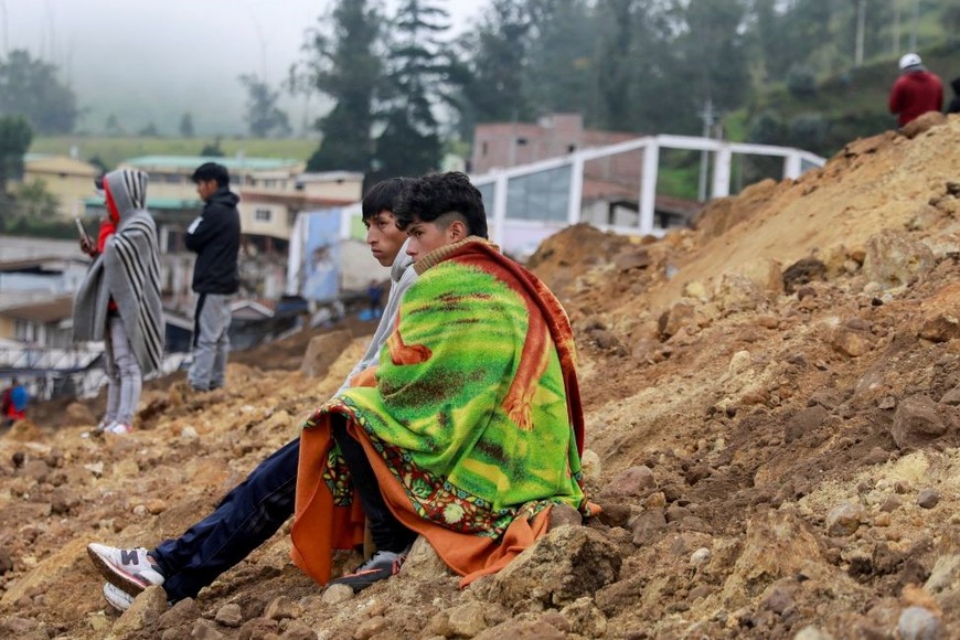 La gente se sienta en medio de los escombros. Créditos: Karen Toro/Reuters