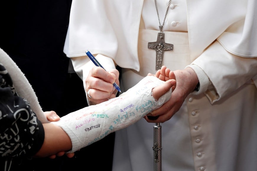 Pope Francis writes on boy's cast as he leaves Rome's Gemelli hospital in Rome, Italy, April 1, 2023. REUTERS/Remo Casilli