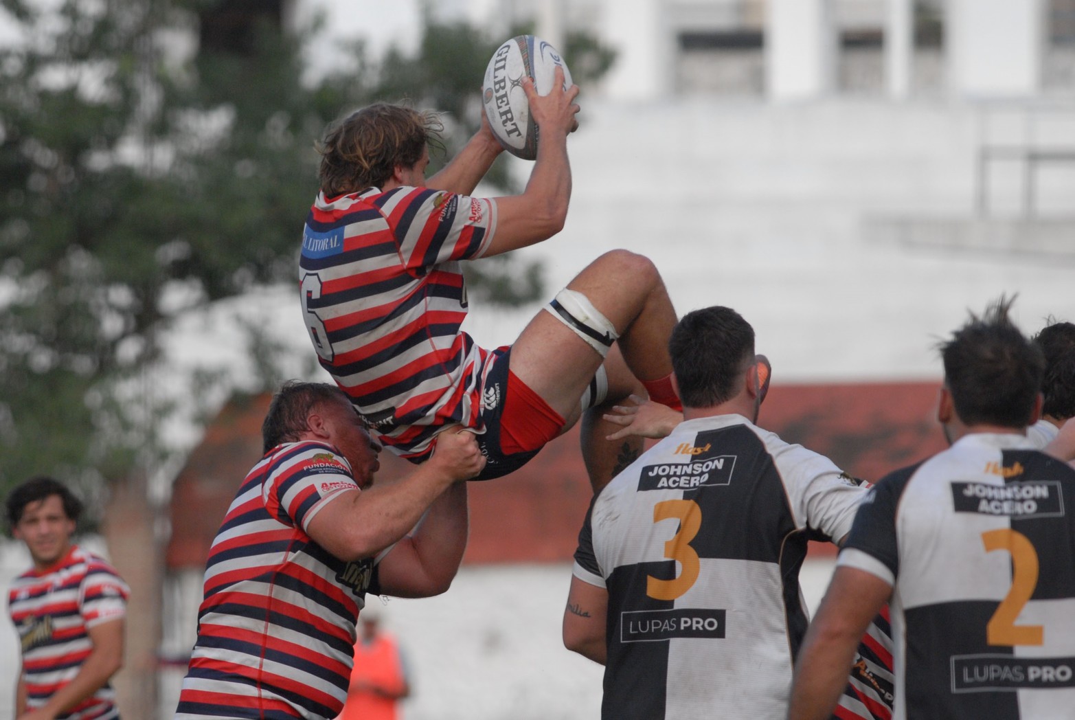 A Agusto Gorla lo sostiene un compañero. Santa Fe Rugby logró un importante triunfo en Paraná. Dominó y venció 36 a 21 al Club Estudiantes.