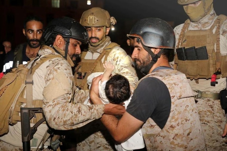 Miembros de la Marina saudí atienden a un niño durante la evacuación. Créditos: Reuters