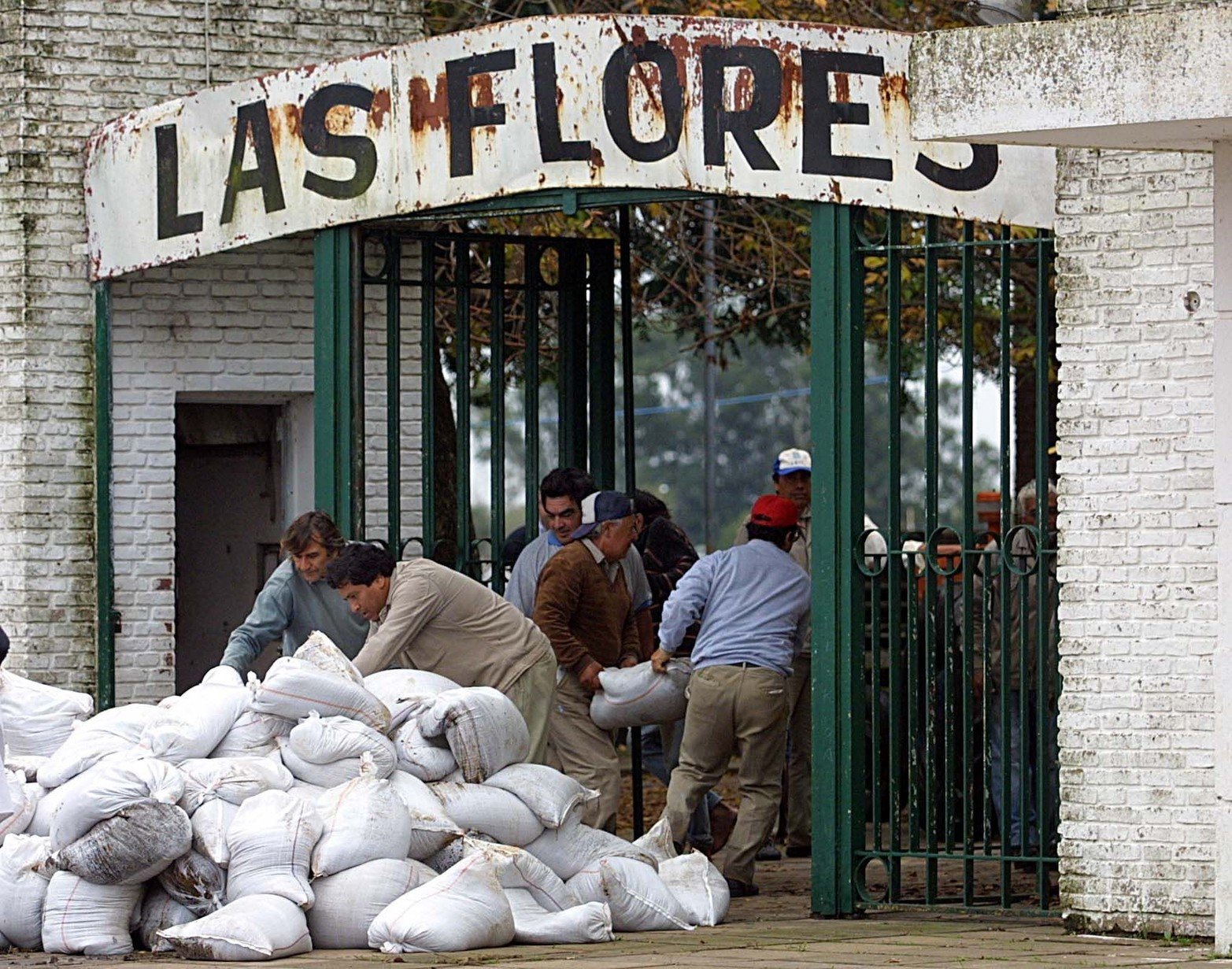 El lunes 28 de abril de 2003. 8.00 de la mañana. Operarios del hipódromo intenta armar una defensa con bolsa de arena ante la inminente llegada del agua a la zona.