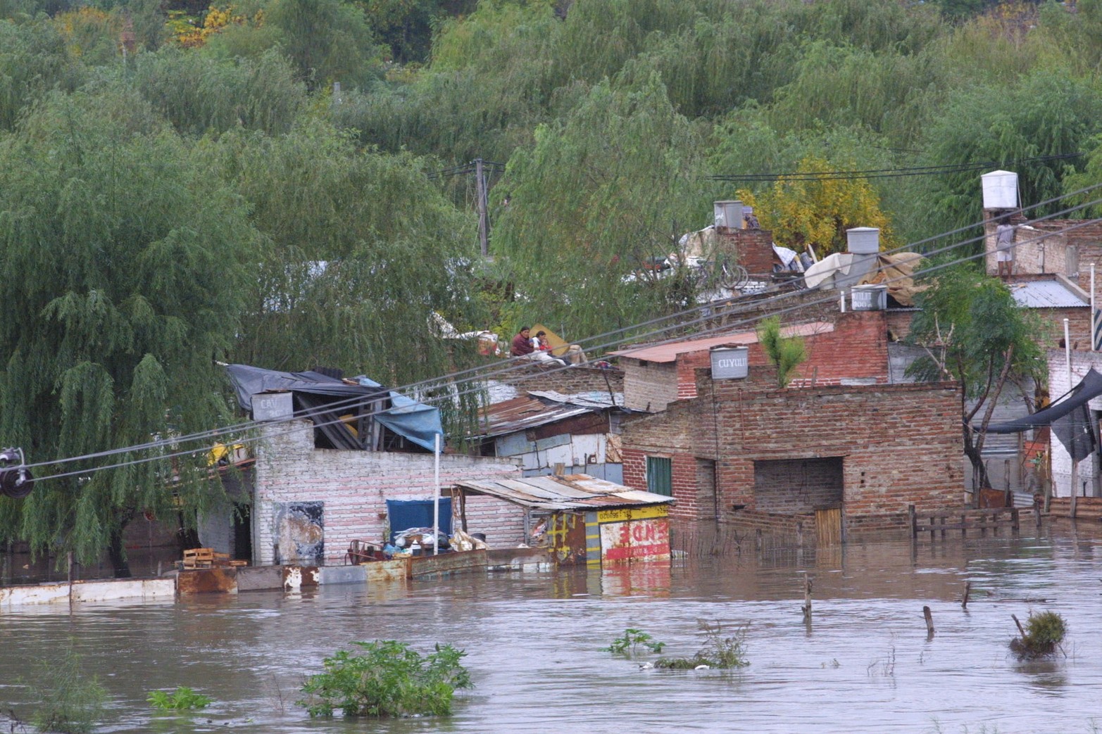 En barrio Alfonso, dos mujeres y una pequeña niña sobreviven arriba de un techo de la intempestiva subida del agua del río Salado.