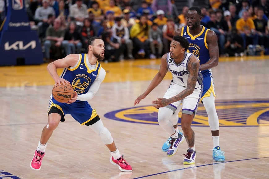Apr 28, 2023; San Francisco, California, USA; Golden State Warriors guard Stephen Curry (30) holds onto the ball next to Sacramento Kings guard Malik Monk (0) in the fourth quarter during game six of the 2023 NBA playoffs at the Chase Center. Mandatory Credit: Cary Edmondson-USA TODAY Sports
