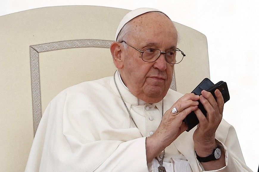 Pope Francis uses a phone during the weekly general audience in St. Peter's Square at the Vatican, May 17, 2023. REUTERS/Guglielmo Mangiapane