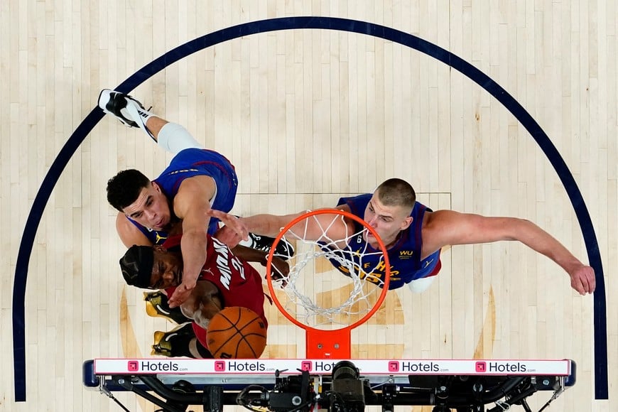 Jun 1, 2023; Denver, CO, USA; Miami Heat forward Jimmy Butler (22) shoots the ball against Denver Nuggets forward Michael Porter Jr. (top) and center Nikola Jokic (right) during the second half in game one of the 2023 NBA Finals at Ball Arena. Mandatory Credit: Jack Dempsey/Pool Photo-USA TODAY Sports